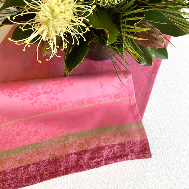 Pink fabric with floral patterns and a bouquet of flowers on a white background