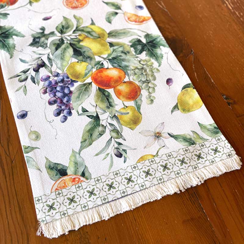 Decorative table runner with fruit and leaf pattern on a wooden surface