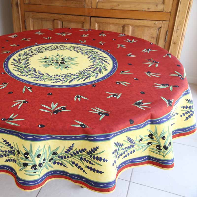 Round tablecloth with lavender and olive design on a wooden table.