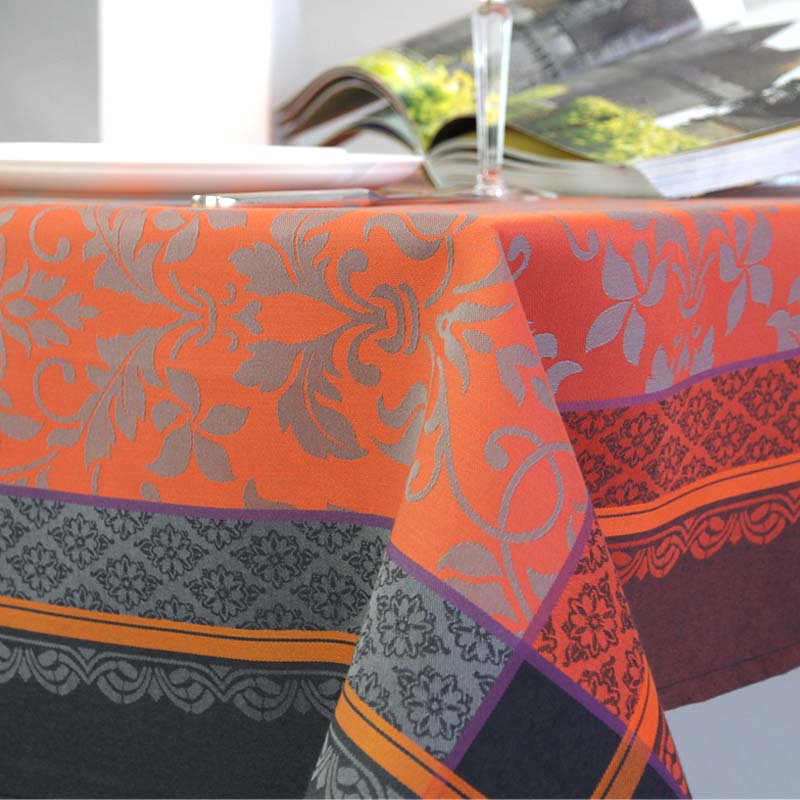Orange and black jacquard tablecloth on a table with a blurred background