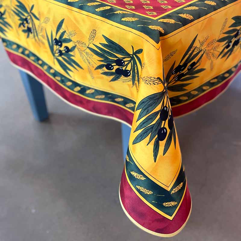 Decorative tablecloth with olive branch and wheat design on a gray surface