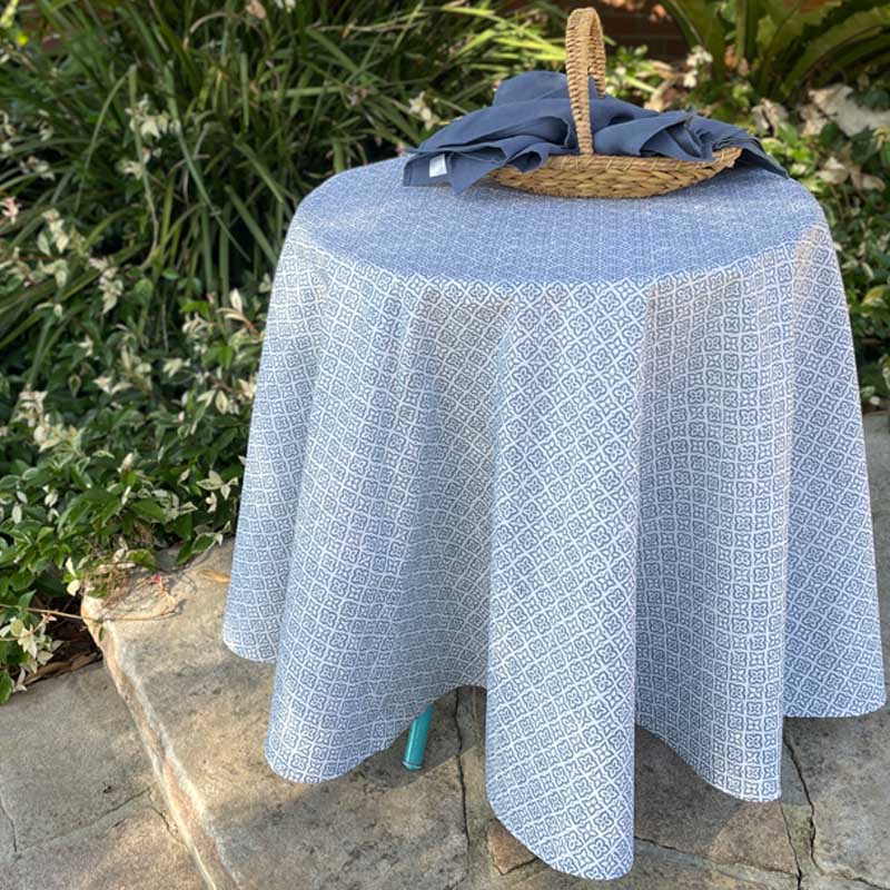 Round table with a blue patterned tablecloth outdoors