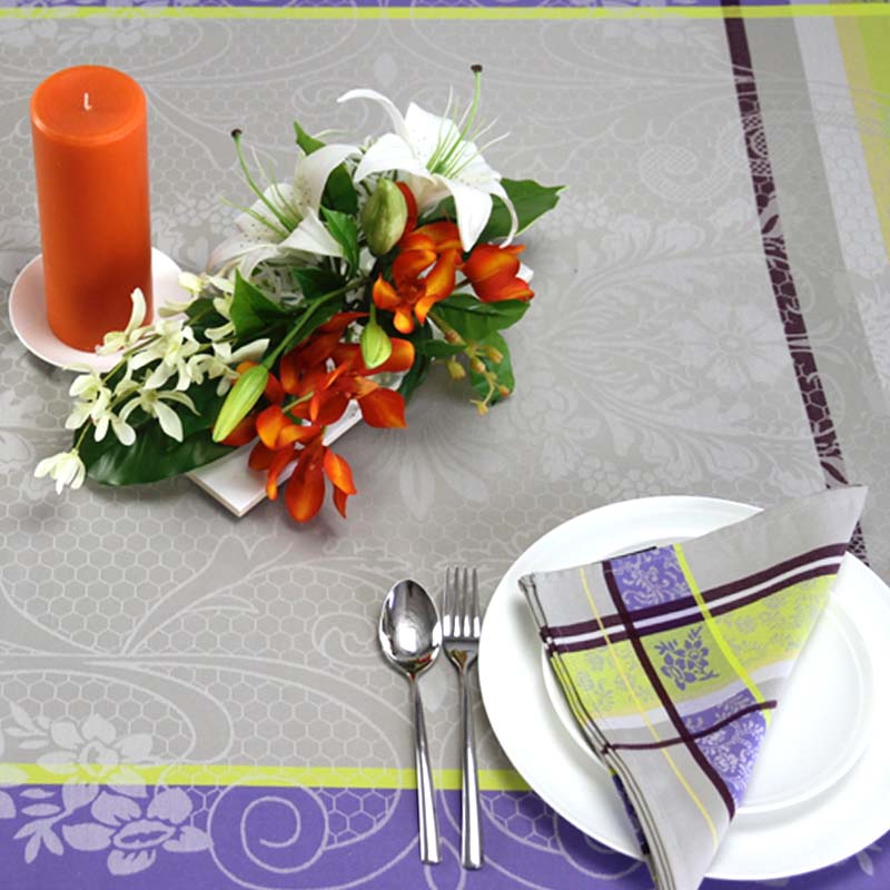 St Tropez jacquard tablecloth with matching napkin and floral arrangement and candle