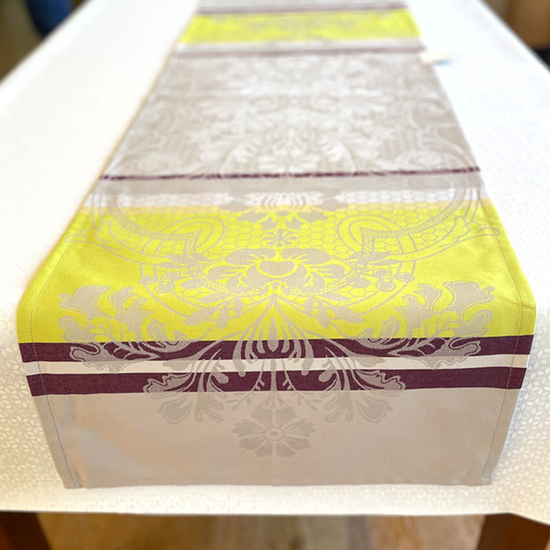 Decorative table runner with yellow and purple patterns on a white surface