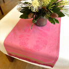 Pink table runner with floral arrangement on a table