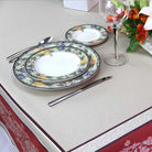 Set of dinnerware with floral design on a tablecloth with decorative border