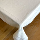 White tablecloth with jacquard weave on a wooden floor