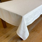 White jacquard tablecloth on a wooden table