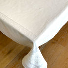 White jacquard tablecloth on a wooden table