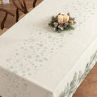 Top of a Christmas tablecloth with fir trees and deer design on the side borders.