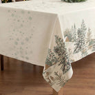 Corner of a Christmas tablecloth with fir trees and deer design on the side borders.