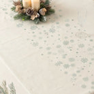 Top of a Christmas tablecloth with a snowflake pattern down the middle