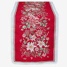 A festive Christmas table runner with a vibrant red background, featuring a detailed floral and botanical pattern in white, green, and gold, finished with a white border.