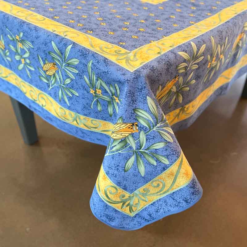 Blue tablecloth with yellow and green floral patterns on a wooden table.