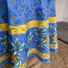 Blue tablecloth with yellow and green patterns featuring cicadas and leaves.