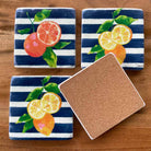 Set of 4 resin drink coasters in Citrus Blue design. Cork backing. Oranges and lemons on a navy blue and white striped background.