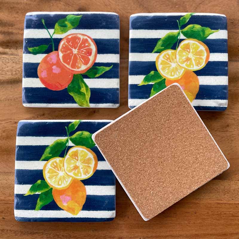 Set of 4 resin drink coasters in Citrus Blue design. Cork backing. Oranges and lemons on a navy blue and white striped background.