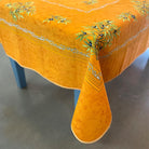 Orange tablecloth with floral patterns on a table