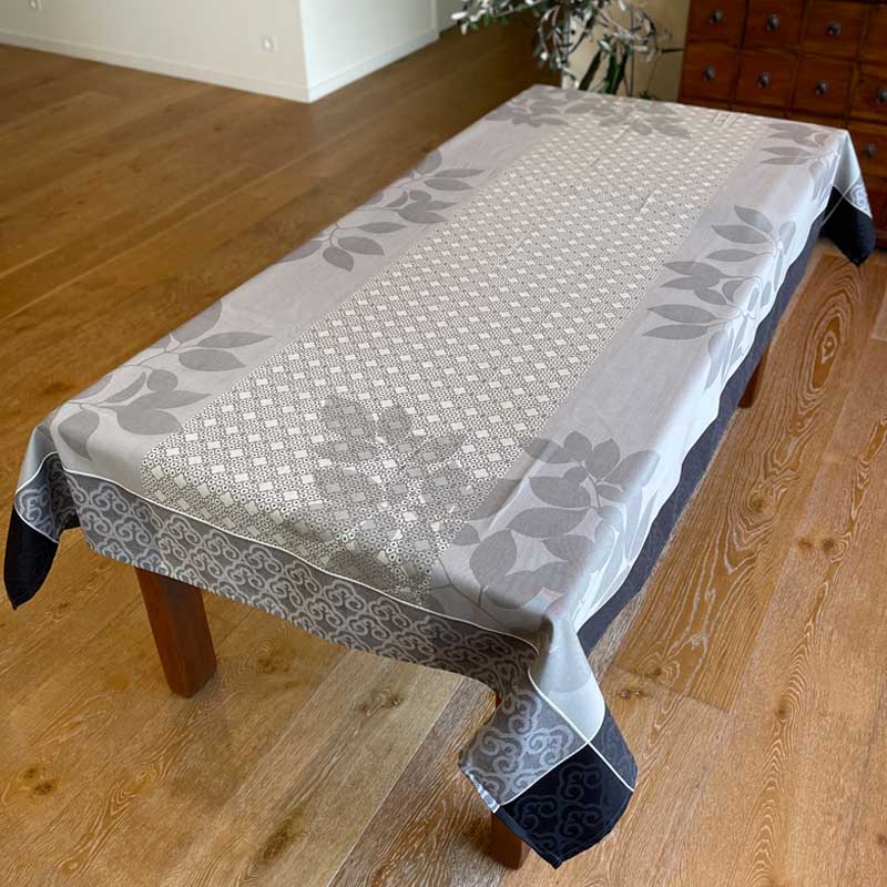 Tablecloth with a leaf pattern on a wooden table in a room.