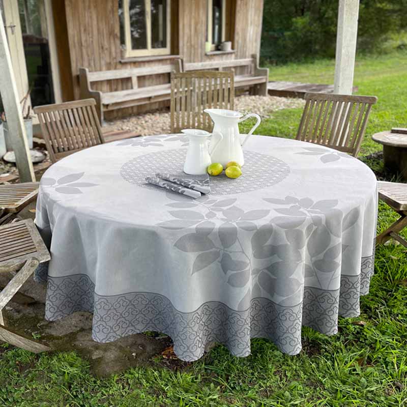 Round table with a patterned tablecloth outdoors in a garden setting