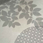 Closeup of uneven discolouration in the grey woven fabric of a Deauville Grey round jacquard tablecloth sold as seconds