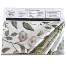 A folded piece of French Affair stain resistant tablecloth fabric with a floral print, shown with its white paper header card containing product details and a list of stain resistant options.