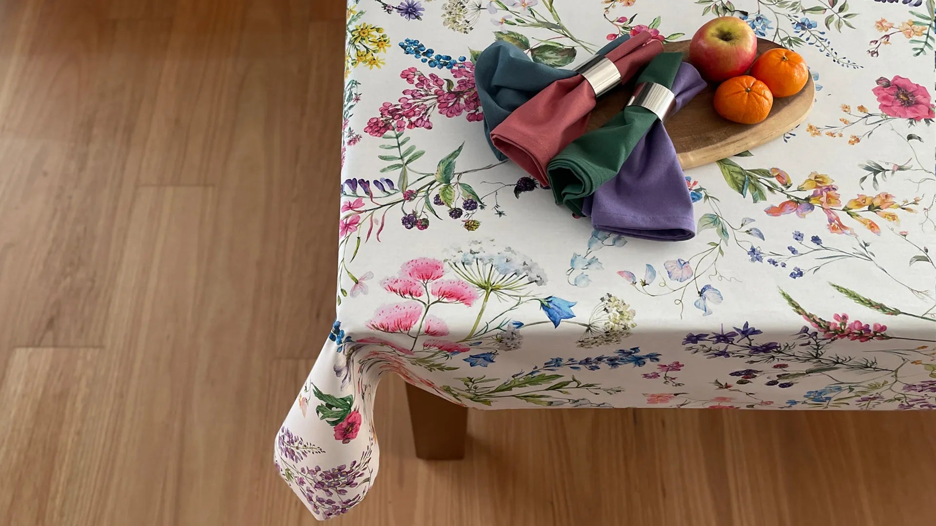 Fortuna tablecloth of floral pattern on a white background on a table with napkins and fruit