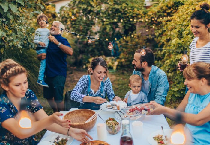 Family enjoying a meal outdoors in a garden setting