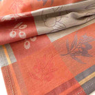 Close-up of patterned fabric with red, beige, and gray colors.