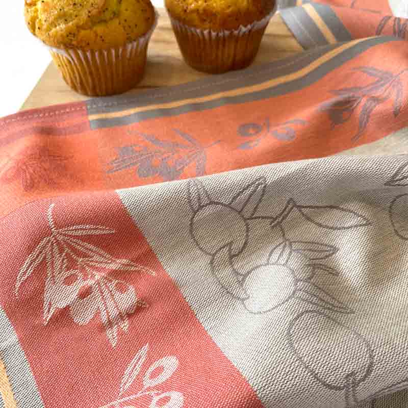 Floral-patterned tablecloth with muffins on a wooden surface