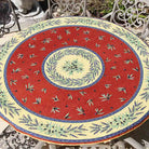 Decorative round tablecloth with a red background featuring olives and lavender