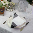Dining table setting with plates, cutlery, and decorative items on a white tablecloth.
