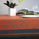 Decorative Orange and black jacquard tablecloth on a set dining table.