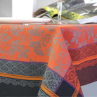 Orange and black jacquard tablecloth on a table with a blurred background