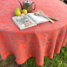 Decorative tablecloth with a book, lemons, and a teapot on a grassy surface