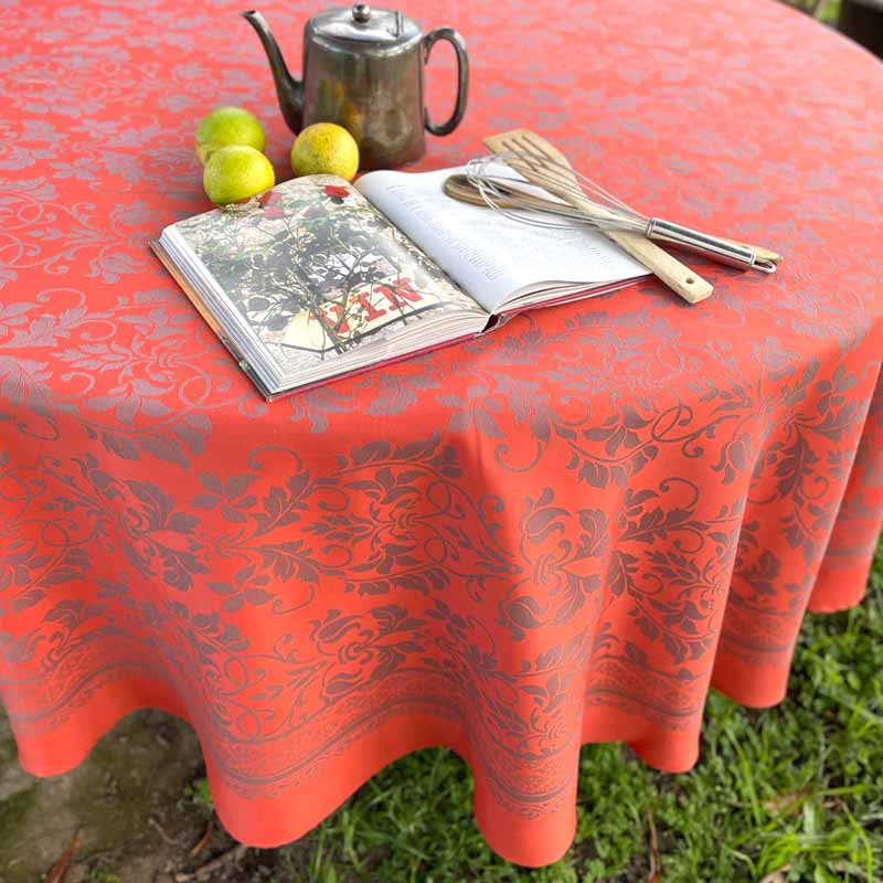 Decorative tablecloth with a book, lemons, and a teapot on a grassy surface