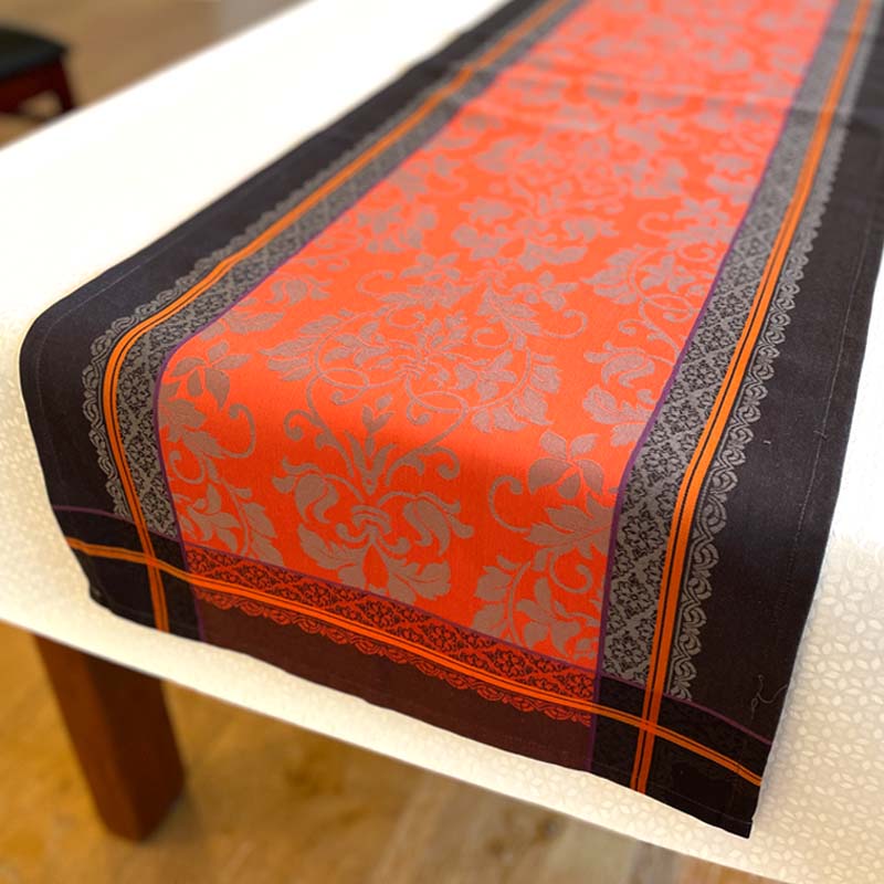 Decorative table runner with intricate patterns on a white table