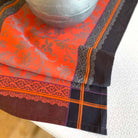 Close-up of a fabric with orange and black patterns on a white surface
