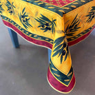 Decorative tablecloth with olive branch and wheat design on a gray surface
