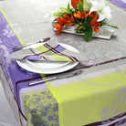 St Tropez jacquard tablecloth with matching napkin sitting on a plate with floral arrangement in the background