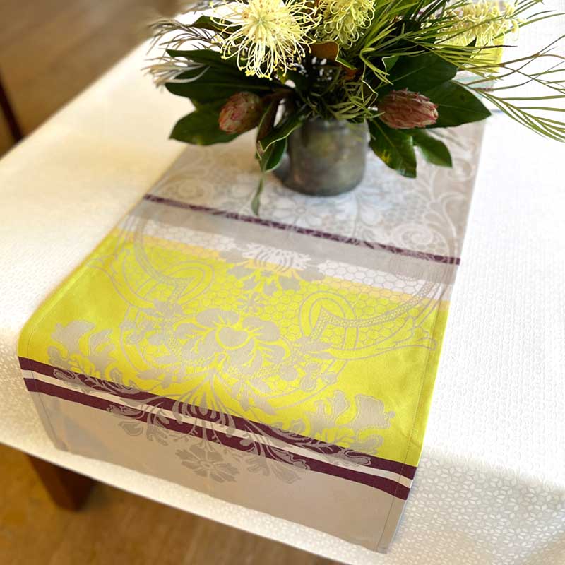 Decorative table runner with floral arrangement on a table