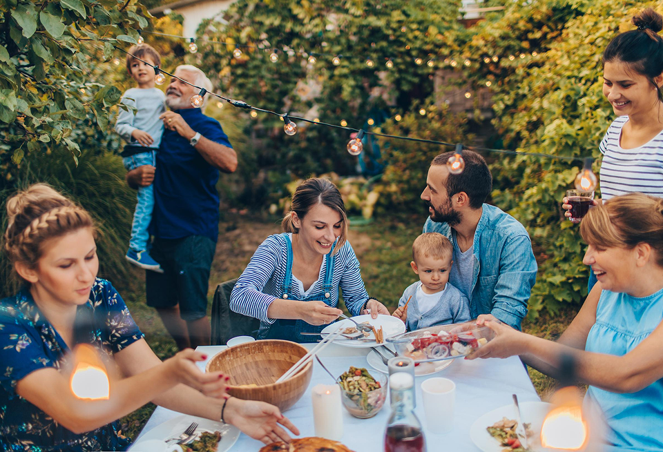 Family enjoying dinner outdoors with French Affair tablecloth – About Page