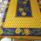 Yellow and blue tablecloth with sunflower design on a table.