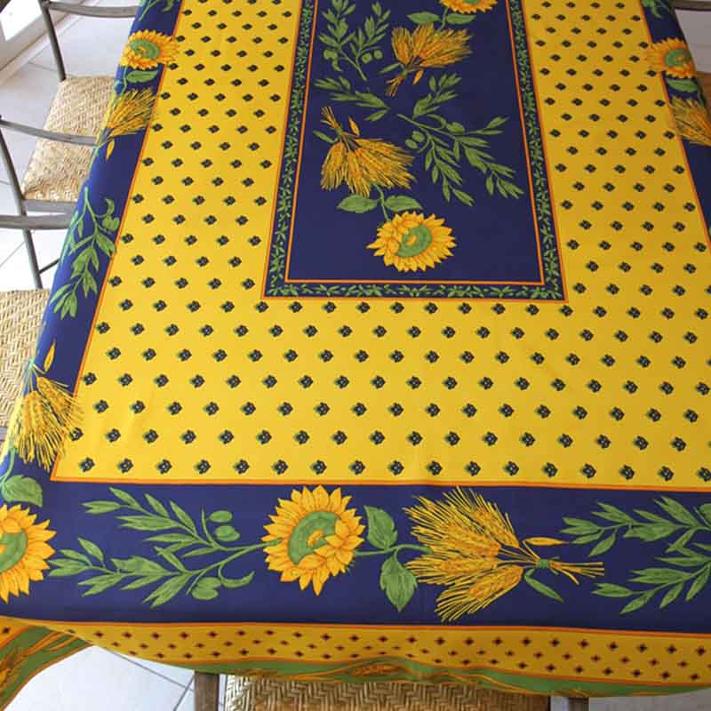 Yellow and blue tablecloth with sunflower design on a table.