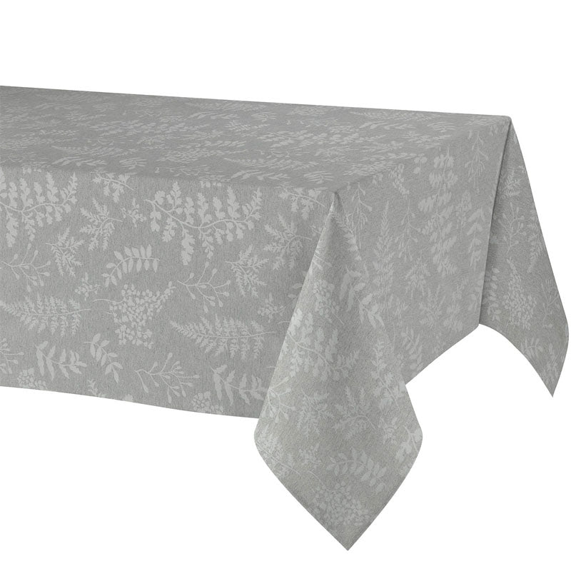 A light gray tablecloth with a subtle white botanical leaf pattern, draped over a table against a plain white background.