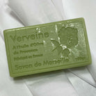 A rectangular bar of green soap labeled 'Verveine Savon de Marseille' resting on a white fabric background.