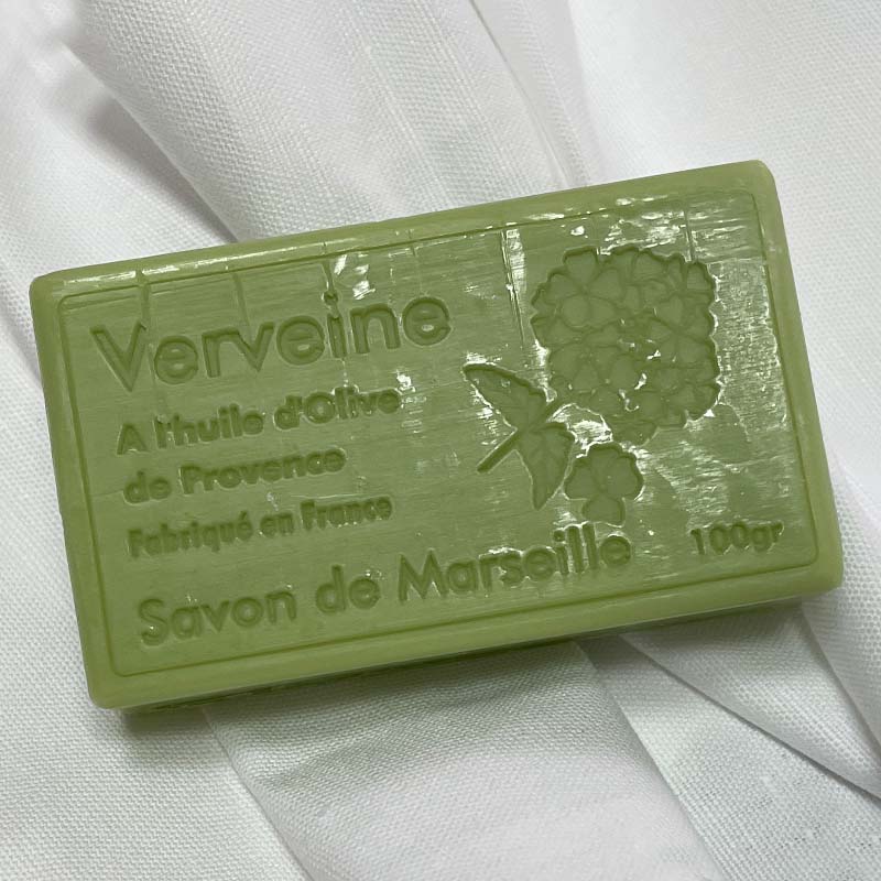 A rectangular bar of green soap labeled 'Verveine Savon de Marseille' resting on a white fabric background.
